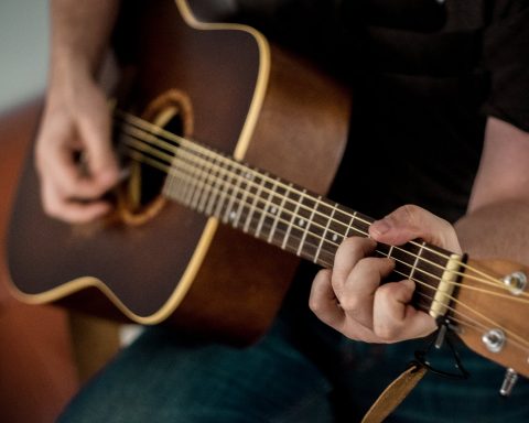 person playing brown guitar