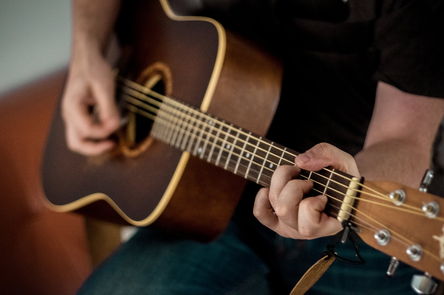 person playing brown guitar