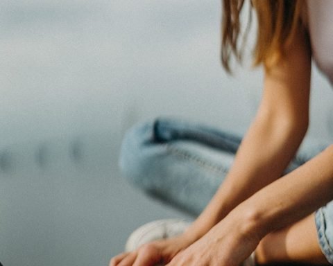 woman sitting on bench browsing laptop