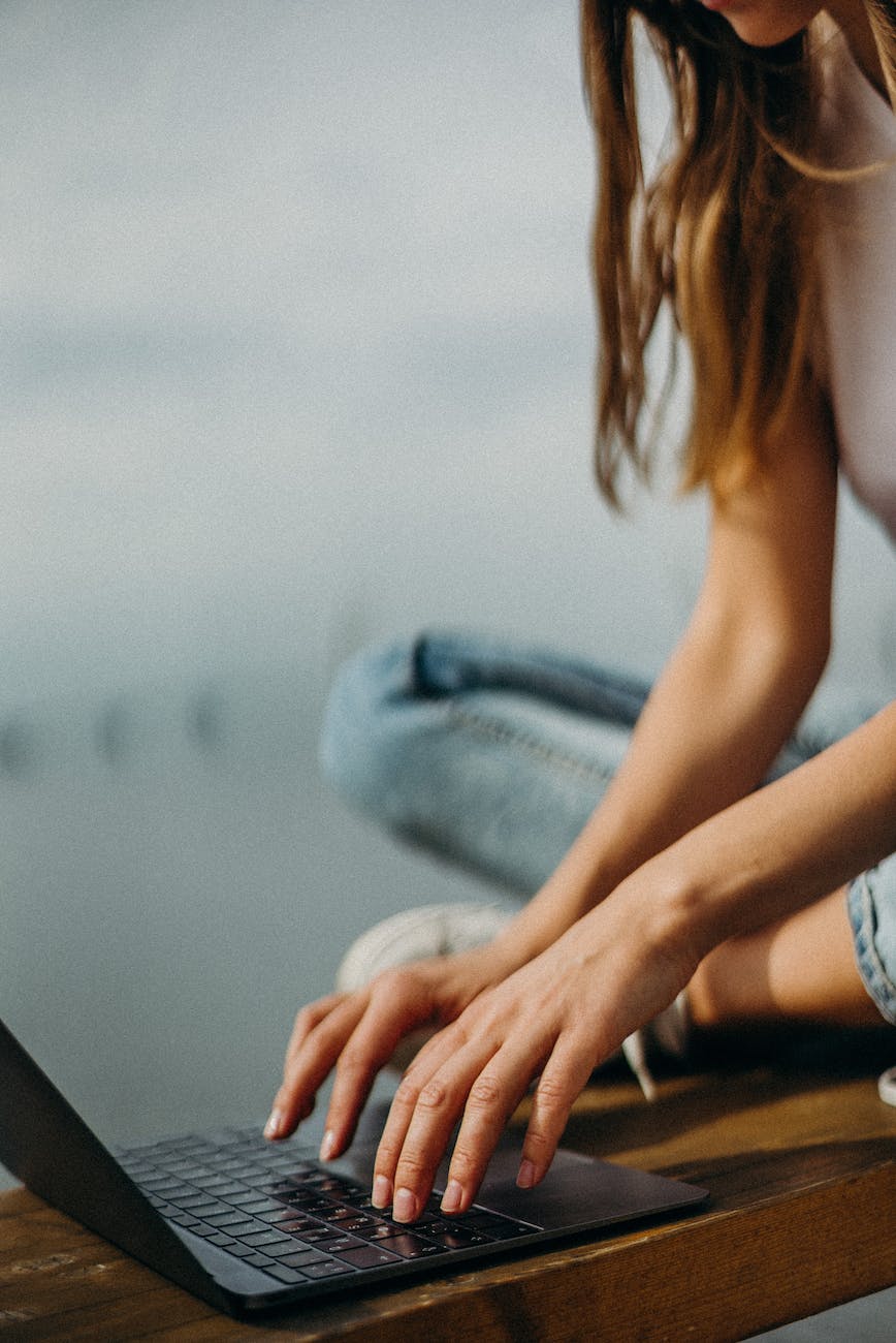 woman sitting on bench browsing laptop