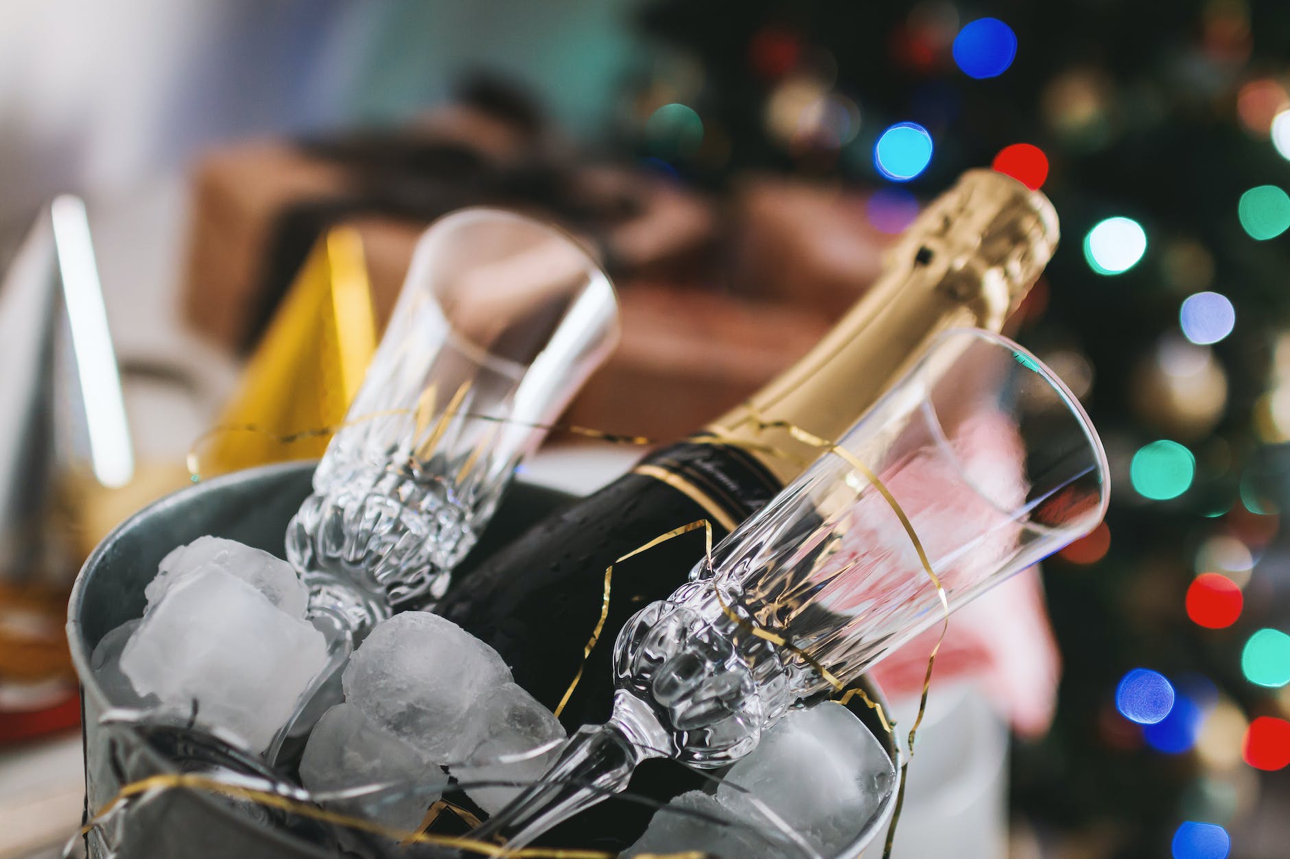 selective focus photography of brown labeled bottle and two clear glass champagne flutes